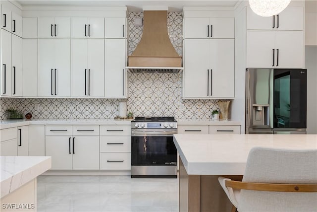 24131 Cock Robin Ln, Bonita Springs, FL 34135 - kitchen with stainless steel appliances, custom range hood, light marble finish flooring, and white cabinets