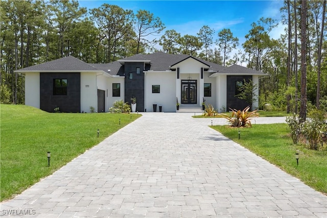24131 Cock Robin Ln, Bonita Springs, FL 34135 - prairie-style home featuring decorative driveway, stucco siding, and a front lawn