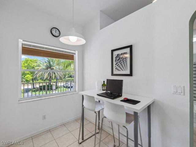 home office with baseboards, light tile patterned floors, and arched walkways