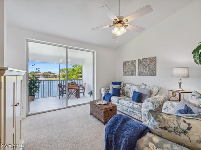 carpeted living area with vaulted ceiling and a ceiling fan
