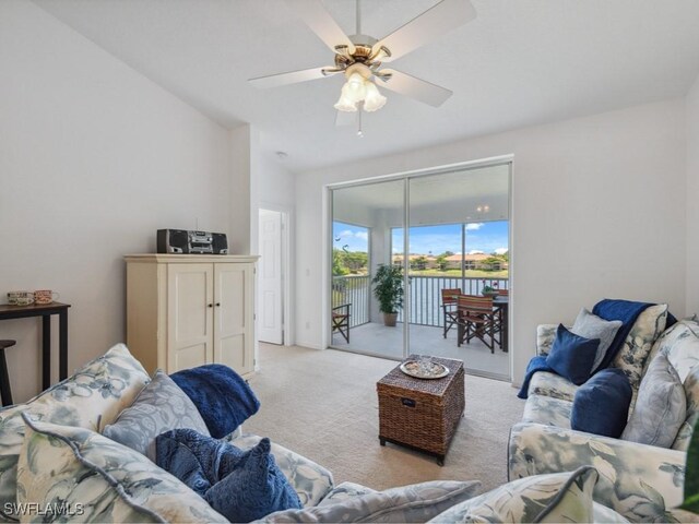 living area with light carpet, a ceiling fan, and lofted ceiling