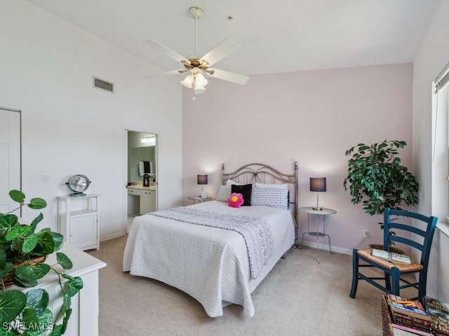 bedroom featuring light carpet, vaulted ceiling, baseboards, and ensuite bathroom