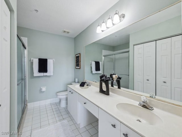 bathroom featuring toilet, tile patterned flooring, a closet, and a stall shower