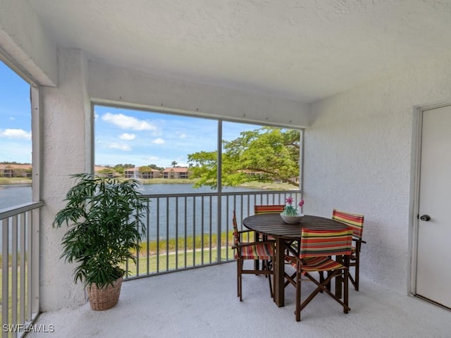 sunroom / solarium featuring a water view