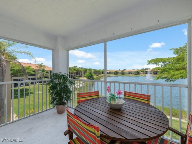 sunroom featuring a water view