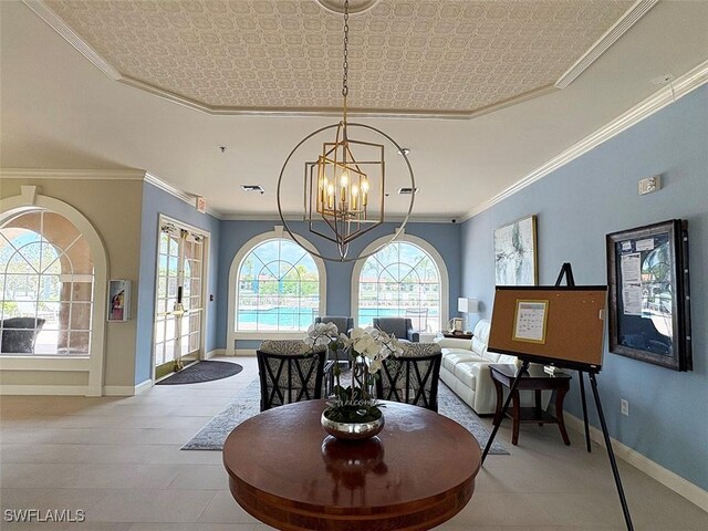 dining area featuring a chandelier, baseboards, crown molding, a tray ceiling, and an ornate ceiling