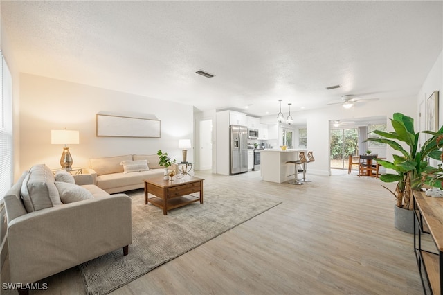 5863 Millay Ct, North Fort Myers, FL 33903 - living room featuring light wood finished floors, a ceiling fan, and baseboards