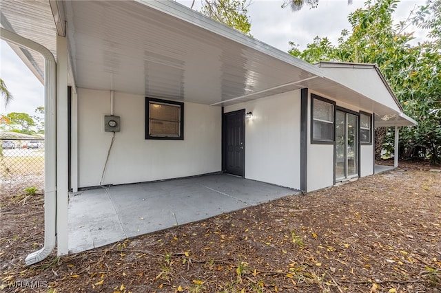 5863 Millay Ct, North Fort Myers, FL 33903 - property entrance featuring a patio, an attached carport, and fence