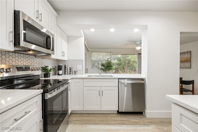5863 Millay Ct, North Fort Myers, FL 33903 - kitchen with appliances with stainless steel finishes, tasteful backsplash, light countertops, light wood-style floors, and a ceiling fan