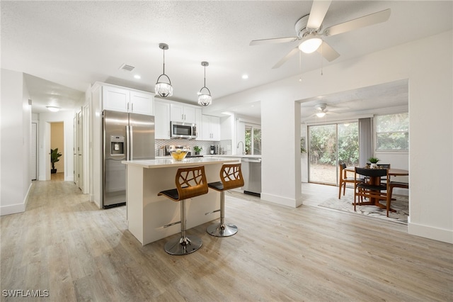 5863 Millay Ct, North Fort Myers, FL 33903 - kitchen with appliances with stainless steel finishes, a kitchen island, light wood-style floors, baseboards, and recessed lighting