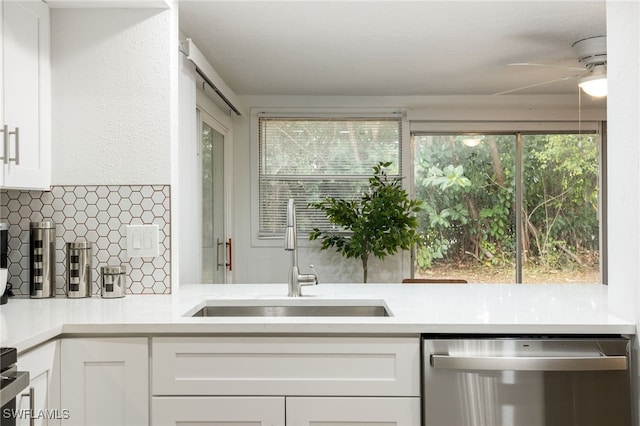 5863 Millay Ct, North Fort Myers, FL 33903 - kitchen with stainless steel dishwasher, a sink, ceiling fan, tasteful backsplash, and white cabinets