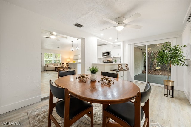 5863 Millay Ct, North Fort Myers, FL 33903 - dining space with ceiling fan, light wood-type flooring, baseboards, and a textured ceiling