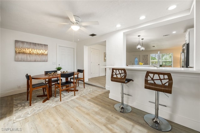 5863 Millay Ct, North Fort Myers, FL 33903 - dining area with a ceiling fan, light wood finished floors, baseboards, recessed lighting, and a chandelier