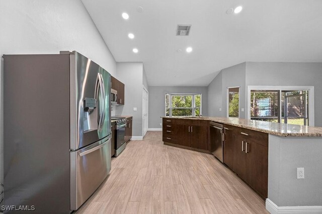 1429 Monarch Cir, Naples, FL 34116 - kitchen with stainless steel appliances, lofted ceiling, dark brown cabinets, light wood-style floors, and recessed lighting