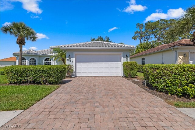 3932 Ruxton Rd, Naples, FL 34116 - view of front of house with decorative driveway, stucco siding, a garage, and a tile roof