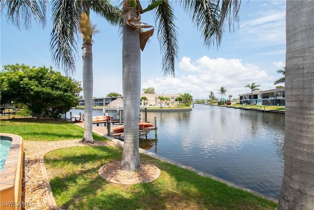 5105 Rutland Ct, Cape Coral, FL 33904 - dock area with boat lift, a water view, and a yard