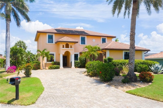 5105 Rutland Ct, Cape Coral, FL 33904 - mediterranean / spanish house with stucco siding, a tiled roof, solar panels, and driveway