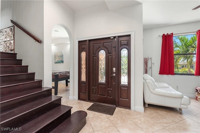 5105 Rutland Ct, Cape Coral, FL 33904 - foyer entrance featuring light tile patterned floors, arched walkways, stairs, and baseboards