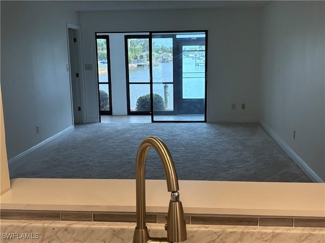 spare room featuring carpet flooring and baseboards