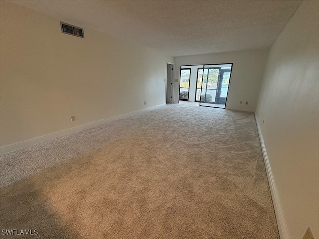 unfurnished room with carpet and baseboards