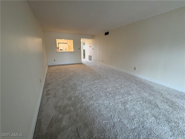 carpeted empty room featuring baseboards