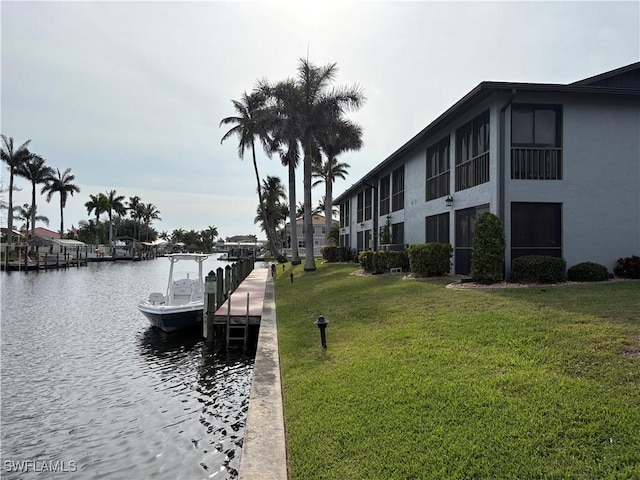 dock area with a yard and a water view