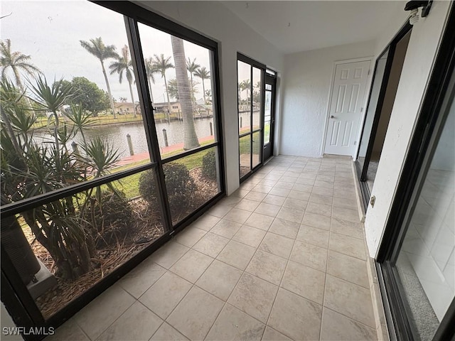 unfurnished sunroom with a water view and tile patterned flooring