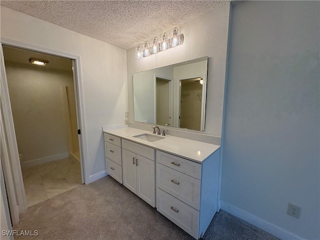 bathroom featuring vanity, a textured ceiling, and baseboards