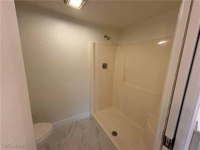 full bathroom with marble finish flooring, a shower, toilet, and baseboards