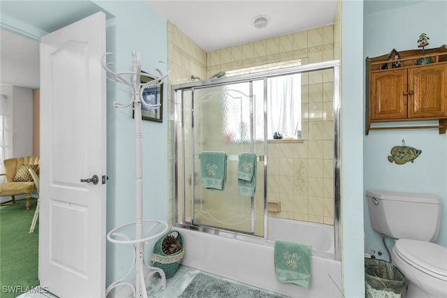 bathroom with bath / shower combo with glass door, toilet, and tile patterned flooring