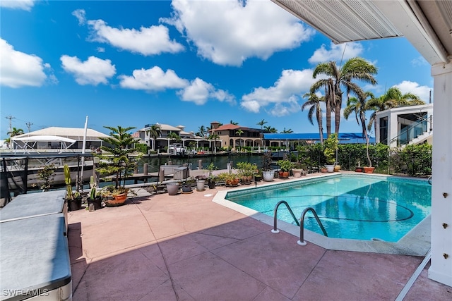 view of swimming pool with a patio area and a water view