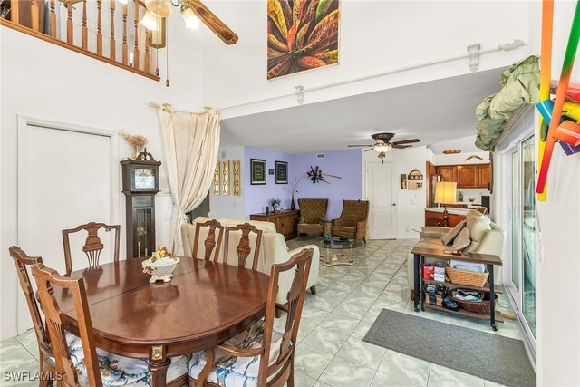 dining room with ceiling fan and a high ceiling