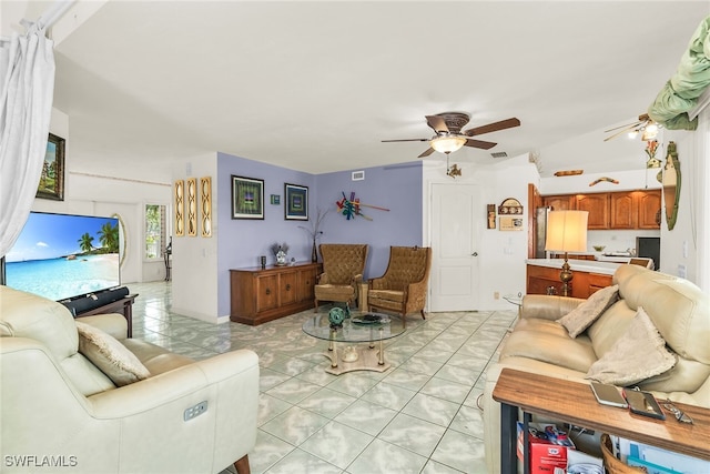 living area featuring ceiling fan and light tile patterned flooring