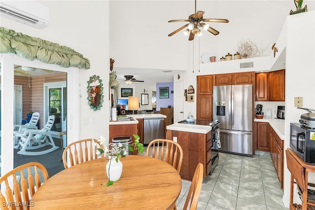 dining area featuring a wall unit AC, ceiling fan, a towering ceiling, and light marble finish flooring