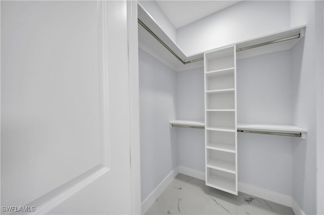 walk in closet featuring marble look tiles