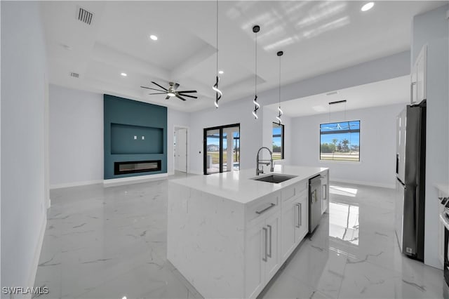 kitchen featuring a sink, stainless steel dishwasher, recessed lighting, freestanding refrigerator, and baseboards