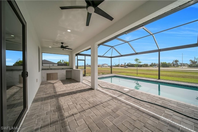 outdoor pool featuring a ceiling fan, a patio, a yard, and a lanai