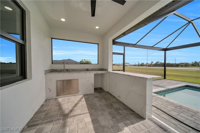 view of patio featuring area for grilling, glass enclosure, ceiling fan, and an outdoor pool