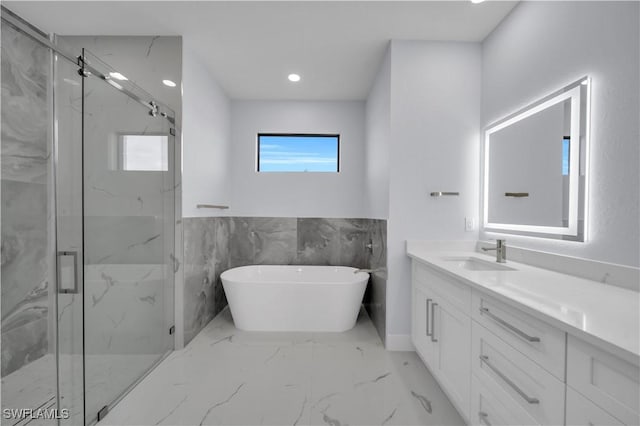 full bath with marble finish flooring, a marble finish shower, vanity, a freestanding tub, and recessed lighting