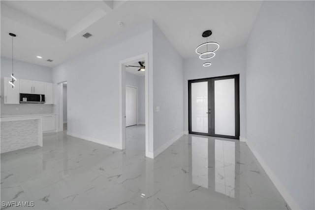 unfurnished living room with light marble finish floors, french doors, and baseboards