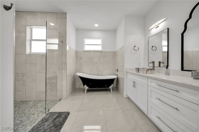 bathroom featuring vanity, a soaking tub, and a walk in shower