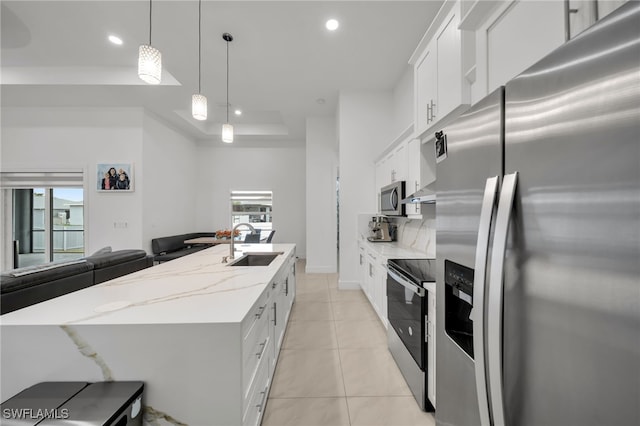 kitchen with appliances with stainless steel finishes, a sink, recessed lighting, a center island with sink, and light tile patterned flooring
