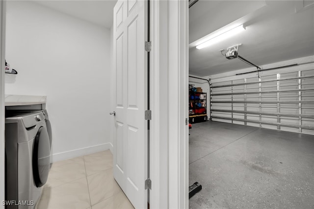 garage with washing machine and clothes dryer, a garage door opener, and baseboards