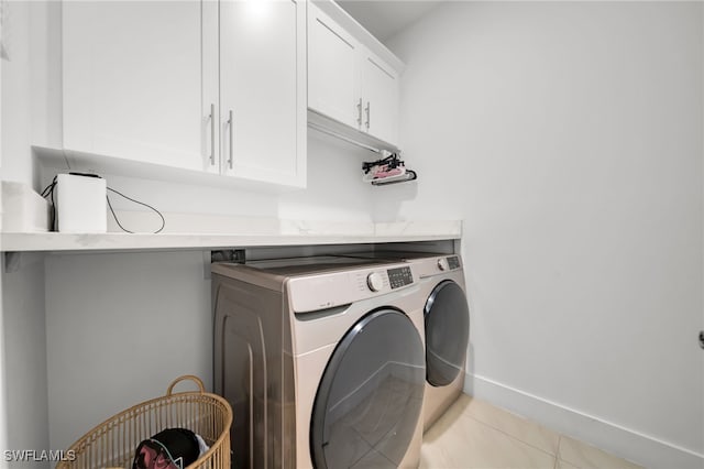 laundry room with independent washer and dryer, cabinet space, tile patterned floors, and baseboards