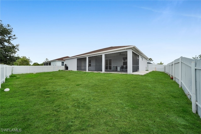 rear view of property featuring a sunroom and a ceiling fan