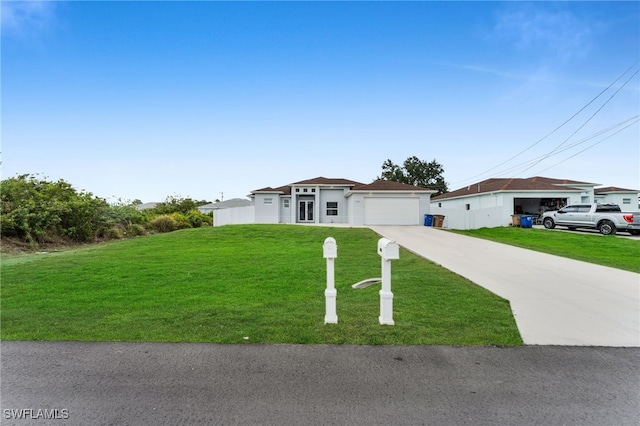 view of front of property featuring a front yard, concrete driveway, and a garage