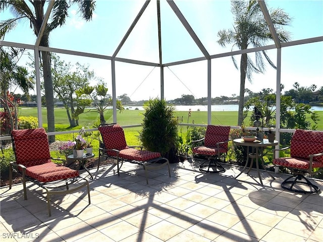 view of patio featuring glass enclosure and a water view