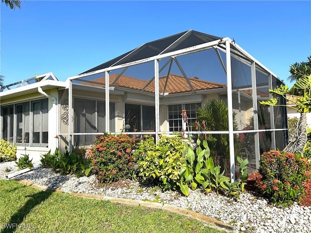 back of property featuring a lanai and stucco siding