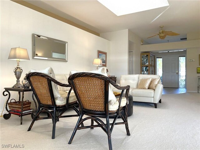 living area featuring light carpet and a ceiling fan