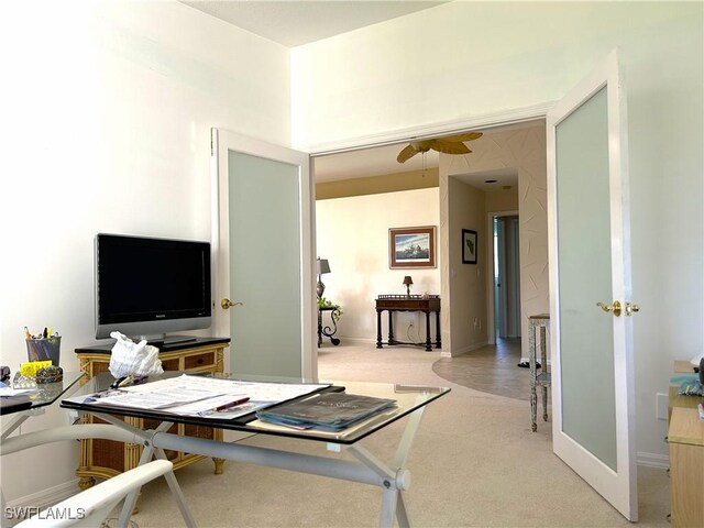 office space with light carpet, ceiling fan, and baseboards
